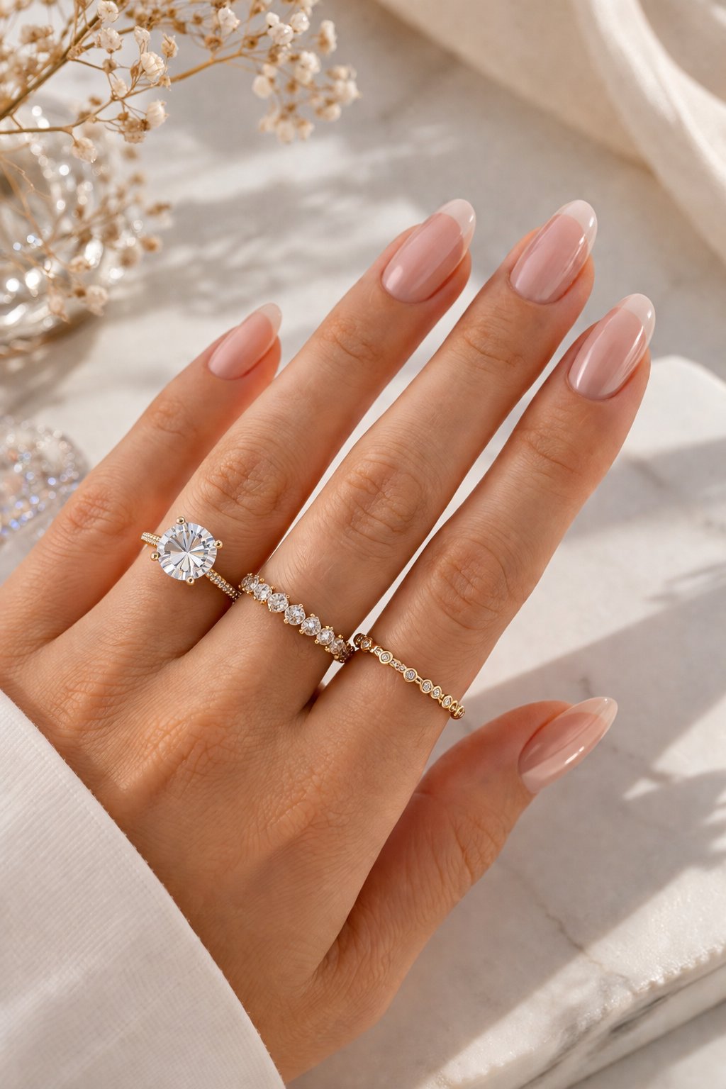 Ästhetische Kombination aus drei goldenen Ringen mit Diamanten an einer gepflegten Hand – Ringgröße Guide von HEJSCHMUCK