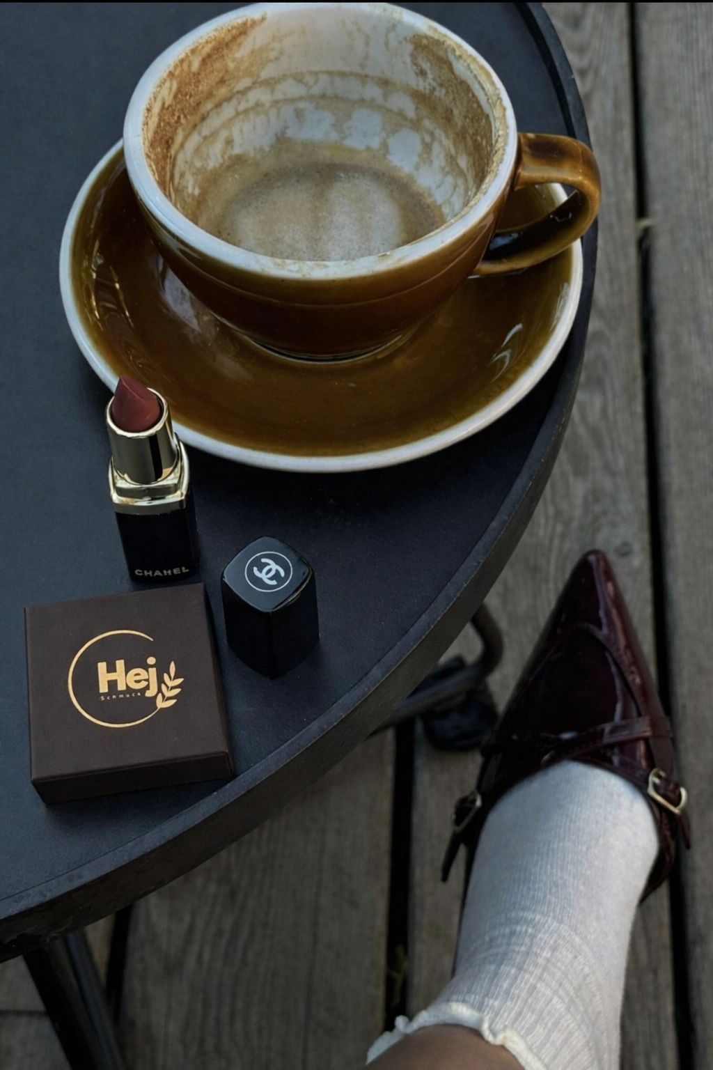 Lifestyle-Foto von HejSchmuck New Arrivals: elegante Schmuckbox auf einem Café-Tisch neben Kaffeetasse, Lippenstift und stilvollem Outfit – moderner, minimalistischer Schmuck-Look