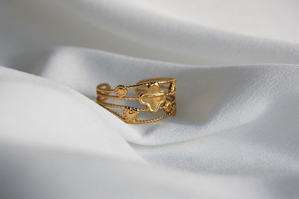 Der Sara-Ring ist ein bezaubernder Kleeblattring, der mehr als nur ein Accessoire ist – er ist eine Hommage an die natürliche Schönheit. Verstellbar und aus Edelstahl gefertigt, mit einer 14k Vergoldung, unterstreicht dieses stilvolle und bedeutungsvolle Schmuckstück perfekt deine Persönlichkeit und deinen Stil.