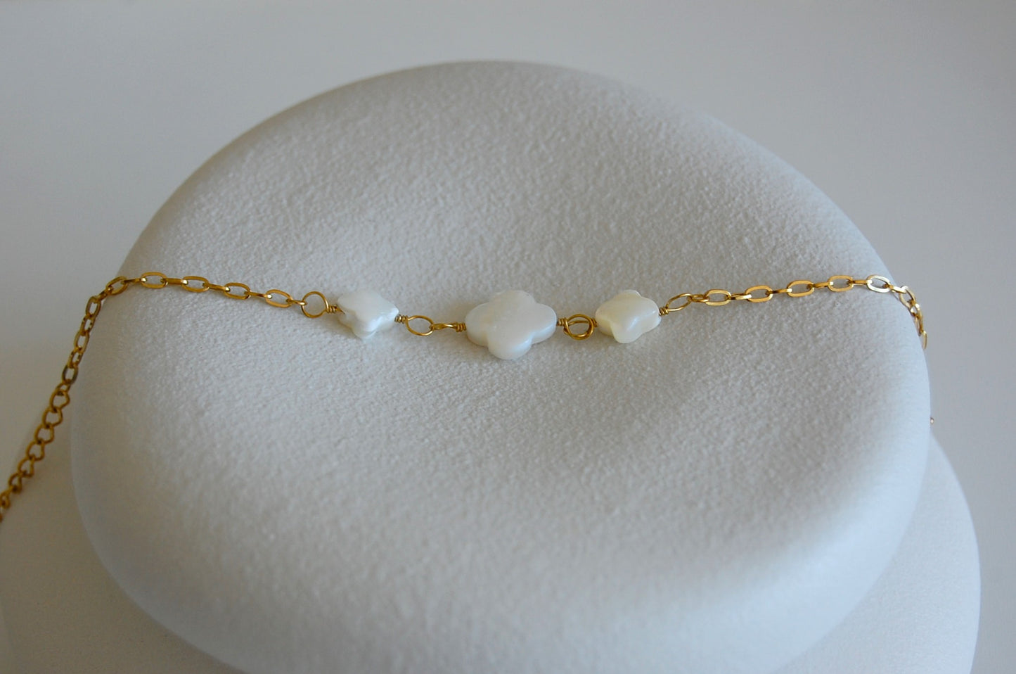 Entdecke die zarte Eleganz des Viola Armbands mit drei weißen Kleeblättern aus Perlmutt. Gefertigt aus Edelstahl, verleiht es deinem Handgelenk sommerliche Leichtigkeit und zeitlose Schönheit.