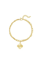 Zweilagiges Diva Armband aus 14k vergoldetem Edelstahl mit einem feinen Strang, einer groben Gliederkette und einem goldenen Blumenanhänger auf weißem Hintergrund.