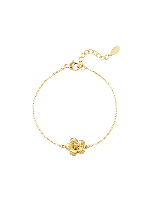 Goldenes Bali Armband aus 14k vergoldetem Edelstahl mit einer einzelnen strukturierten Blüte in der Mitte vor weißem Hintergrund