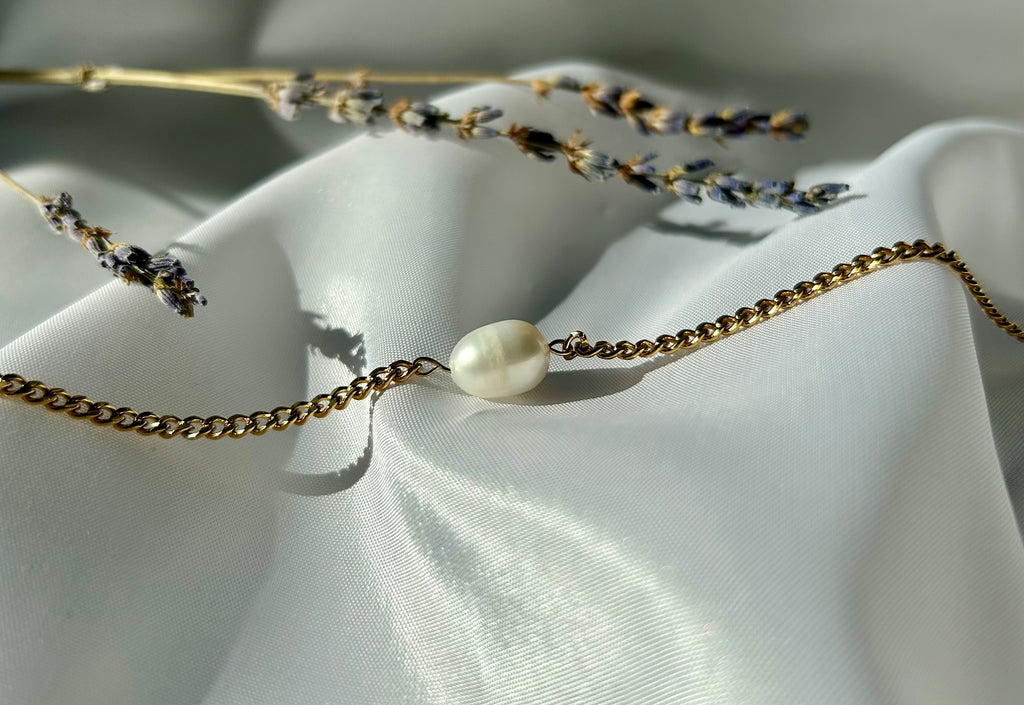 Diese wunderschöne Mona Perlenkette mit einer einzelnen Perle stellt eine Kombination aus zeitloser Eleganz und modernem Design dar. Die Gliederhalskette ist aus hochwertigem Edelstahl und daher nicht nur langlebig, sondern auch hypoallergen und wasserfest.