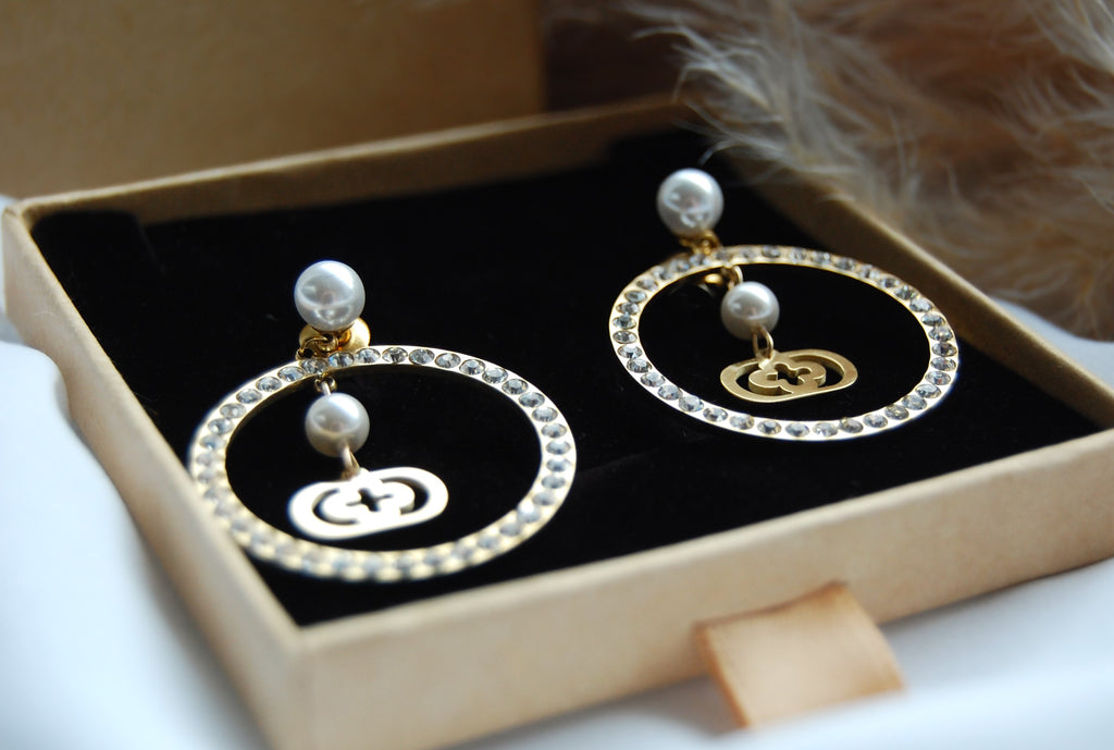 Die Farina Ohrringe sind mit ihrer einzigartigen Kombination aus Perlen, Zirkonia und Gold ein echter Blickfang. Wenn du sie trägst, verleihen sie deinem Look einen Hauch von Raffinesse und Eleganz. Hergestellt aus Edelstahl in Verbindung mit kunstvollen Kunstperlen, sind sie ein Must-Have für deine Schmucksammlung.