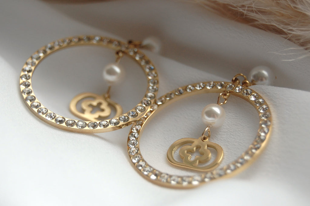 Die Farina Ohrringe sind mit ihrer einzigartigen Kombination aus Perlen, Zirkonia und Gold ein echter Blickfang. Wenn du sie trägst, verleihen sie deinem Look einen Hauch von Raffinesse und Eleganz. Hergestellt aus Edelstahl in Verbindung mit kunstvollen Kunstperlen, sind sie ein Must-Have für deine Schmucksammlung.