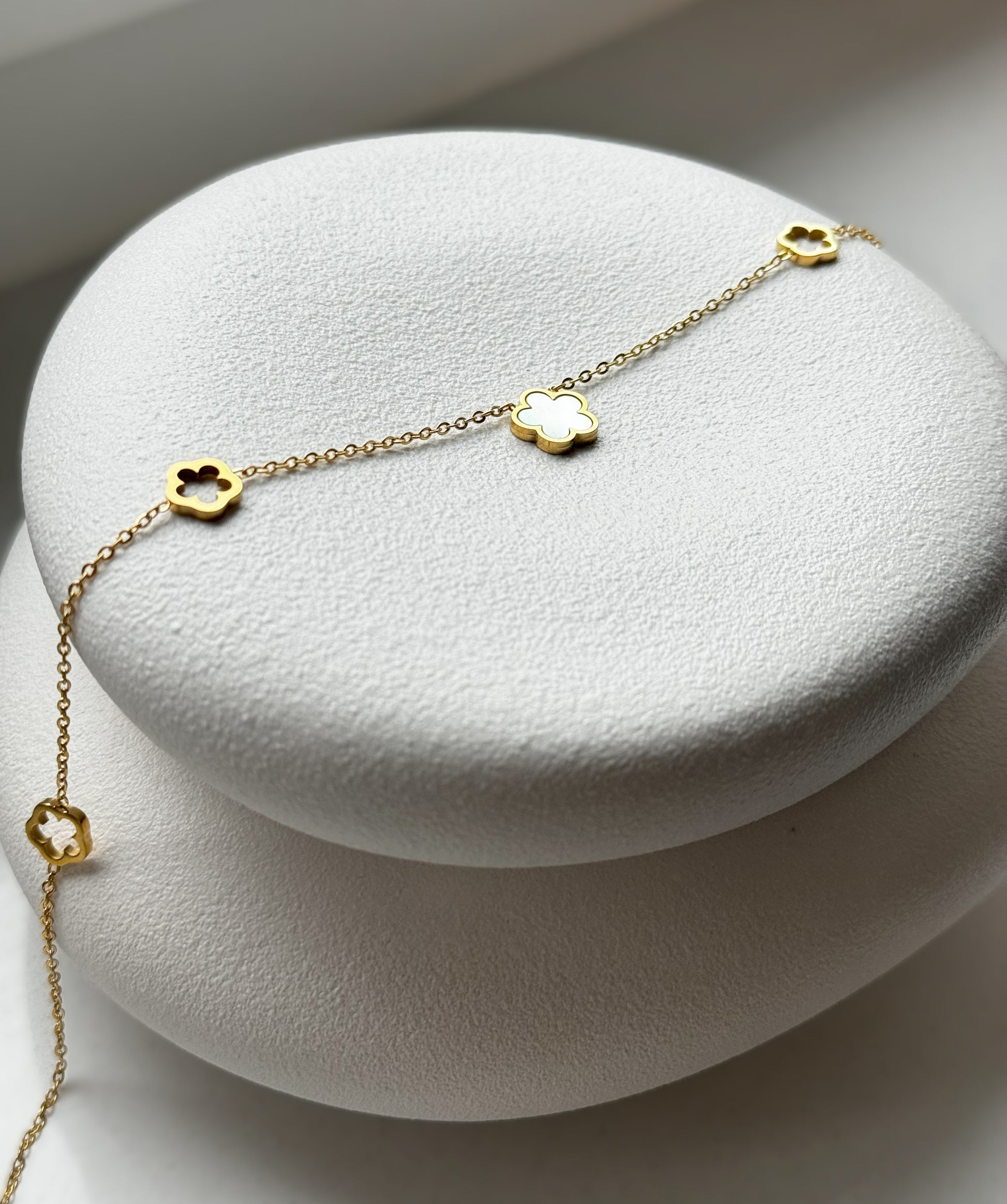 Die elegante Lucy Halskette aus Edelstahl hat in der Mitte einen schicken weißen Kleeblatt-Anhänger aus Perlmutt. An der Kette befinden sich ebenfalls kleine Kleeblätter. Die goldene Farbe sorgt für einen attraktiven Touch, während die Länge von 40 cm mit einer zusätzlichen Verlängerung von 5 cm für flexible Tragbarkeit sorgt.