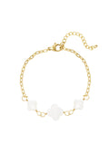 Elegantes Viola Armband aus 14k vergoldetem Edelstahl mit drei weißen Kleeblatt-Anhängern aus Perlmutt auf weißem Hintergrund.