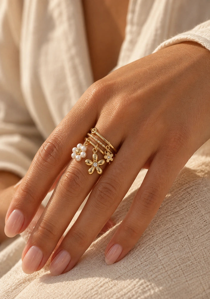Tragebild des Adele Rings aus vergoldetem Edelstahl mit baumelnden Blumen-Charms an der Hand.