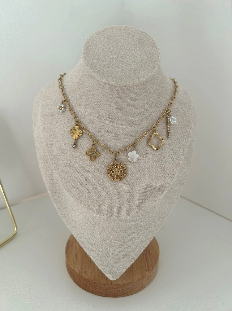 Apolia Charm Halskette in 18k vergoldetem Edelstahl mit vielseitigen Anhängern auf Schmuckbüste.
