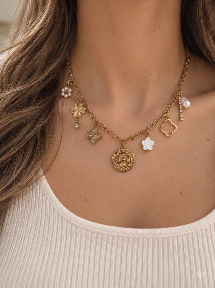Tragefoto der Apolia Charm Halskette aus 18k vergoldetem Edelstahl mit Perlen- und Blüten-Anhängern.