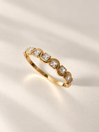 Detailaufnahme des Ariella Armreifs in Gold mit funkelnden Zirkonia-Steinen im Sonnenlicht