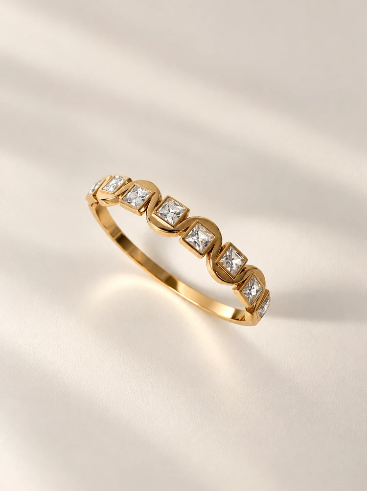 Detailaufnahme des Ariella Armreifs in Gold mit funkelnden Zirkonia-Steinen im Sonnenlicht
