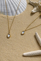 Detailansicht der goldenen Aurora Kette aus Edelstahl im Sonnenlicht am Strand.