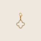 Freigestellter Clover Charm Kleeblatt-Anhänger aus 14k vergoldetem Edelstahl mit funkelndem Zirkonia-Besatz und Karabinerverschluss.