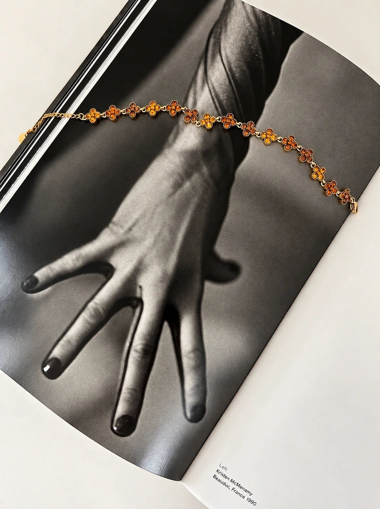 Crystal Bloom Armband mit bernsteinfarbenen Zirkonia-Blüten dekoriert auf den Seiten eines Magazins.