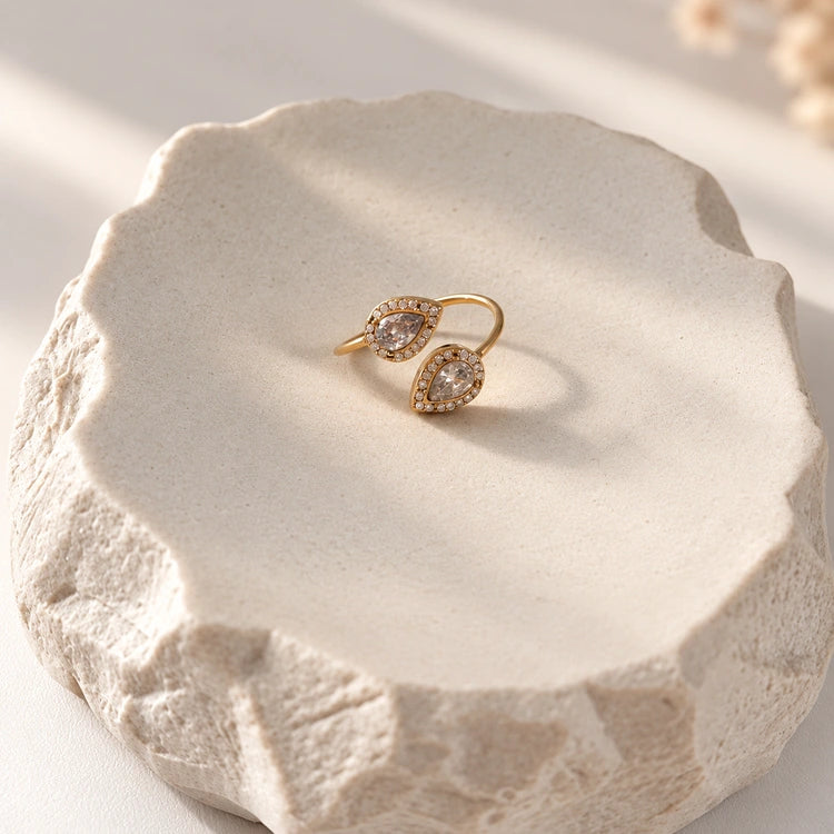 Crystal Drop Ring Gold auf hellem Dekostein mit funkelnden Zirkonia Tropfen