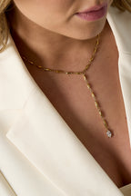 Elegante Mila Y-Halskette aus 14k vergoldetem Edelstahl mit Marquise-Schliff Zirkonia-Kristall getragen zu einem weißen Blazer.