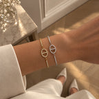 Zwei Dolce Armbänder in Gold und Silber mit Pavé-Zirkonia am Handgelenk