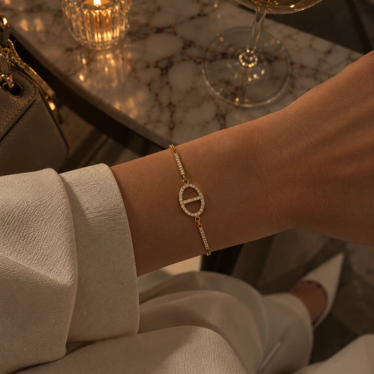 Frau trägt das Dolce Armband in Gold mit Pavé-Zirkonia zu cremefarbenem Outfit