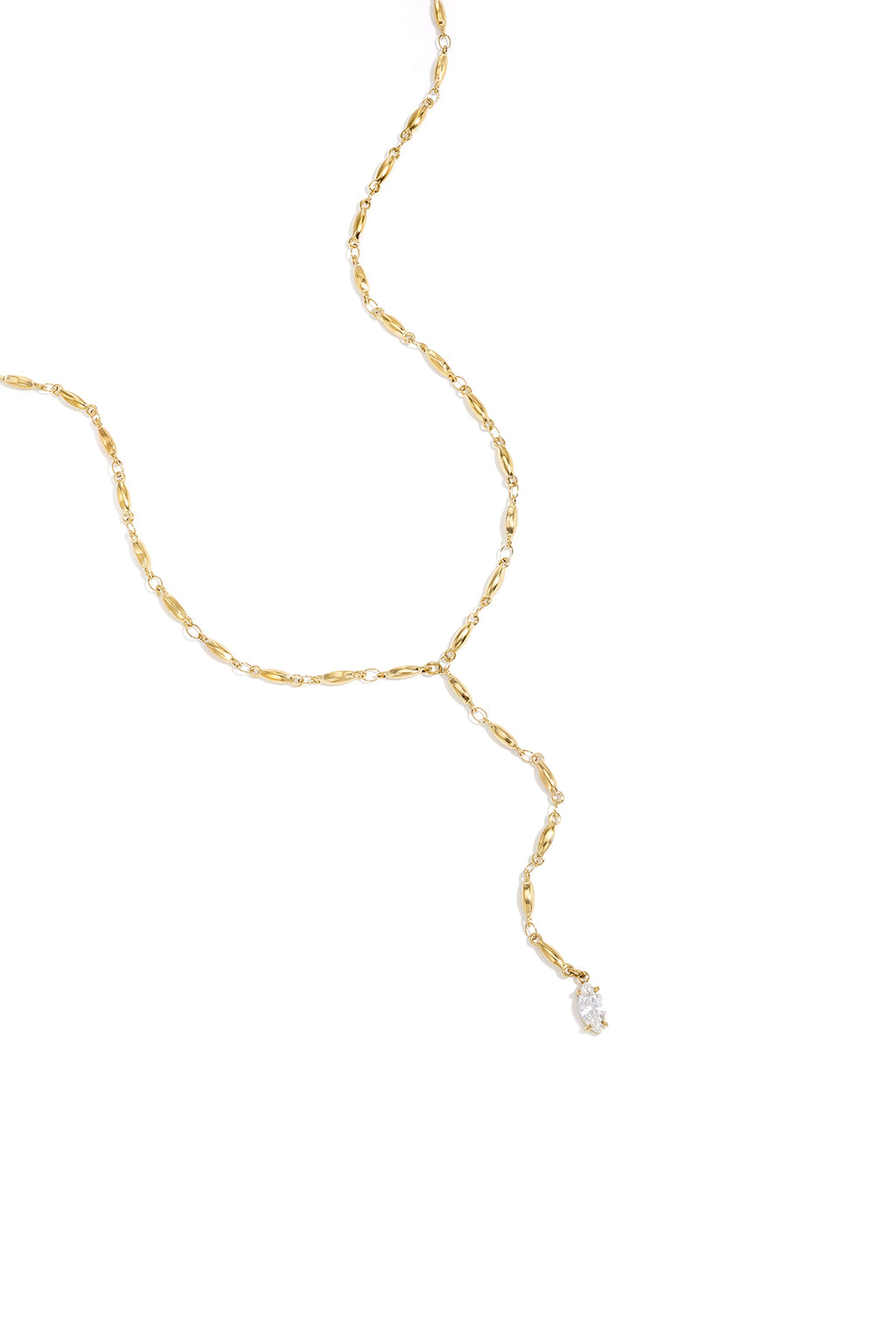 Elegante Mila Y-Halskette aus 14k vergoldetem Edelstahl mit Marquise-Schliff Zirkonia-Kristall getragen zu einem weißen Blazer.