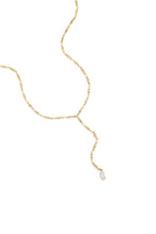 Elegante Mila Y-Halskette aus 14k vergoldetem Edelstahl mit Marquise-Schliff Zirkonia-Kristall getragen zu einem weißen Blazer.