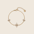 Filigranes Elara Armband aus 14k vergoldetem Edelstahl mit drei funkelnden Zirkonia-Sternen auf hellem Hintergrund.