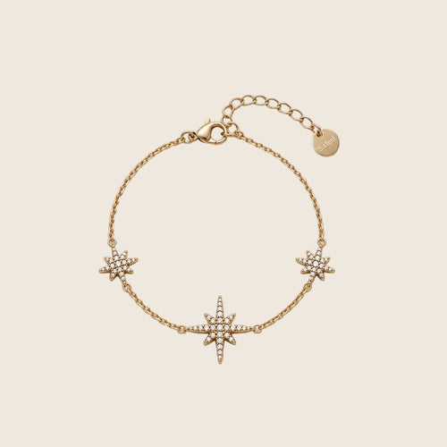 Filigranes Elara Armband aus 14k vergoldetem Edelstahl mit drei funkelnden Zirkonia-Sternen auf hellem Hintergrund.