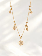 Detailaufnahme der Elara Halskette mit Sternanhängern und Kugelakzenten in Gold