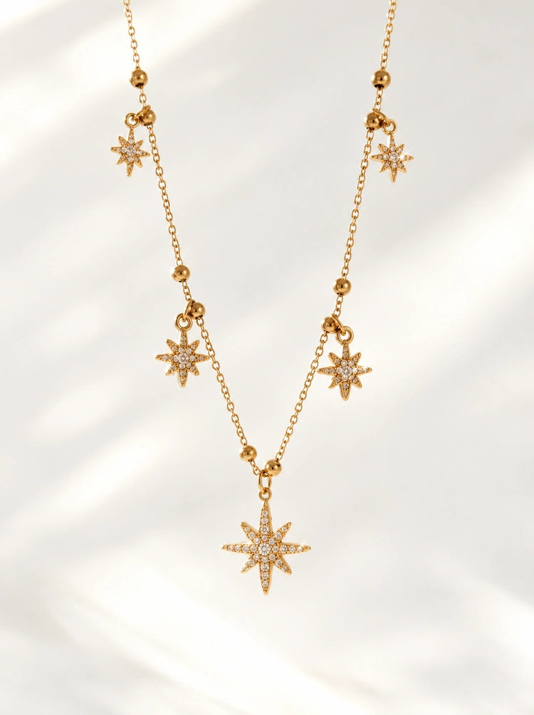 Detailaufnahme der Elara Halskette mit Sternanhängern und Kugelakzenten in Gold