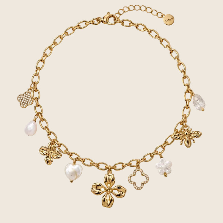 Freigestellte Ansicht der Elicia Halskette mit Charms in Form von Biene, Herzperle, Kleeblatt und Blüte.