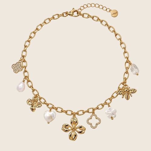 Freigestellte Ansicht der Elicia Halskette mit Charms in Form von Biene, Herzperle, Kleeblatt und Blüte.