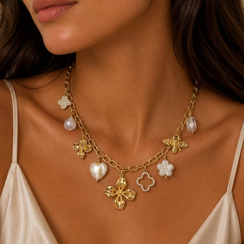 Tragebild der Elicia Charm-Halskette aus 14k vergoldetem Edelstahl mit Bienen- und Blütenanhängern am Dekolleté.
