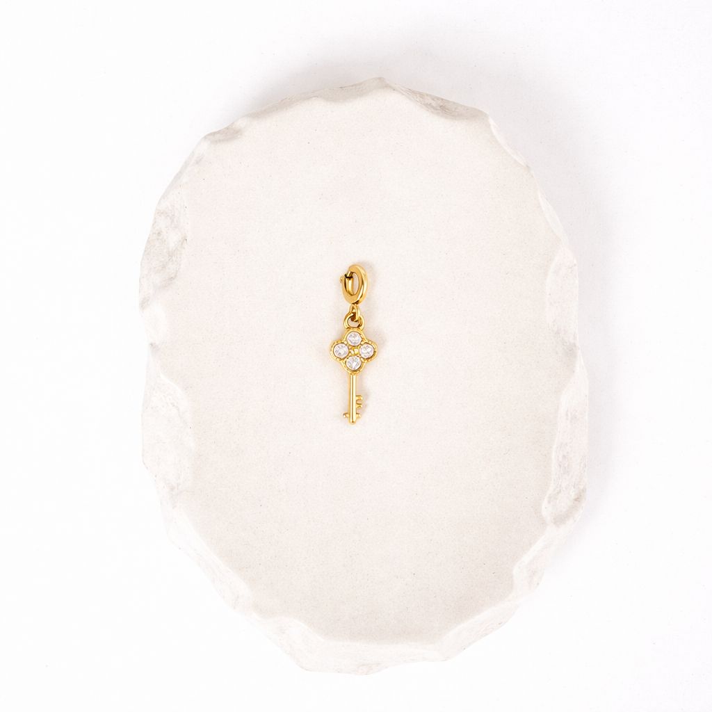Key to My Heart Schlüssel-Charm aus vergoldetem Edelstahl mit Zirkonia auf heller Schmuckunterlage