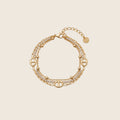 Livia Armband mehrreihig aus 14k vergoldetem Edelstahl mit Zirkonia-Kristallen und Karabinerverschluss auf hellem Hintergrund.