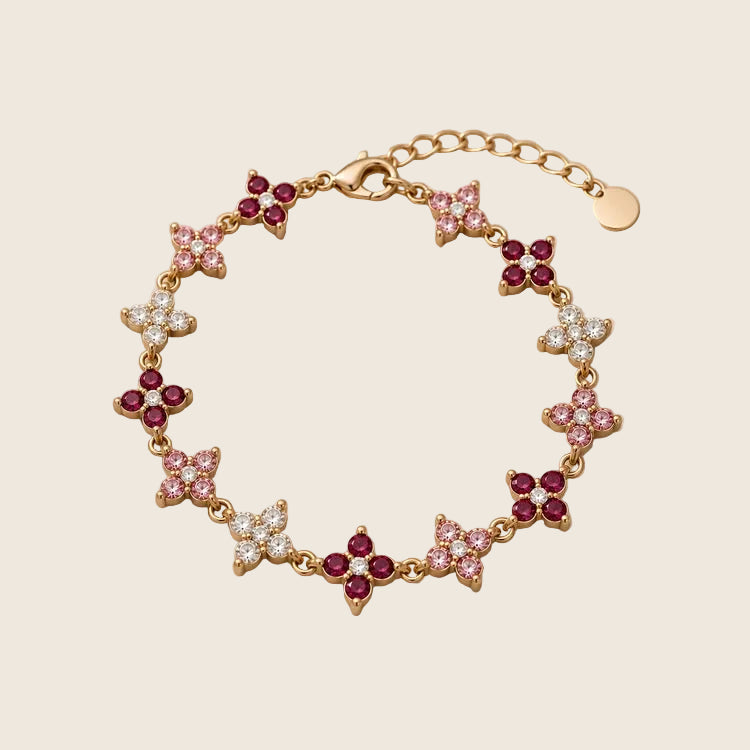 Lucky Bloom Armband aus 18k vergoldetem Edelstahl mit Zirkonia-Kleeblättern in Beerenrot, Pink und Klar.
