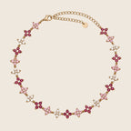 Filigrane Lucky Bloom Halskette aus 18k vergoldetem Edelstahl mit funkelnden Zirkonia-Blüten in Rosa und Beere.