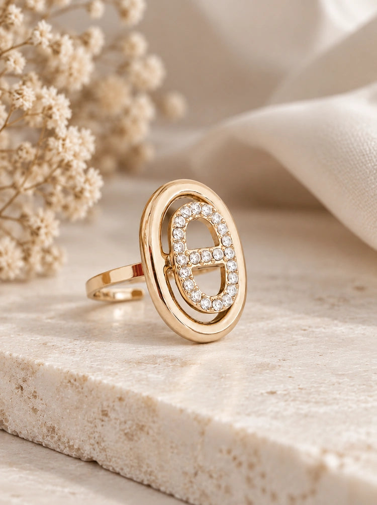 Lumina Ring in Gold mit ovalem Zirkonia-Glied auf heller Steinplatte