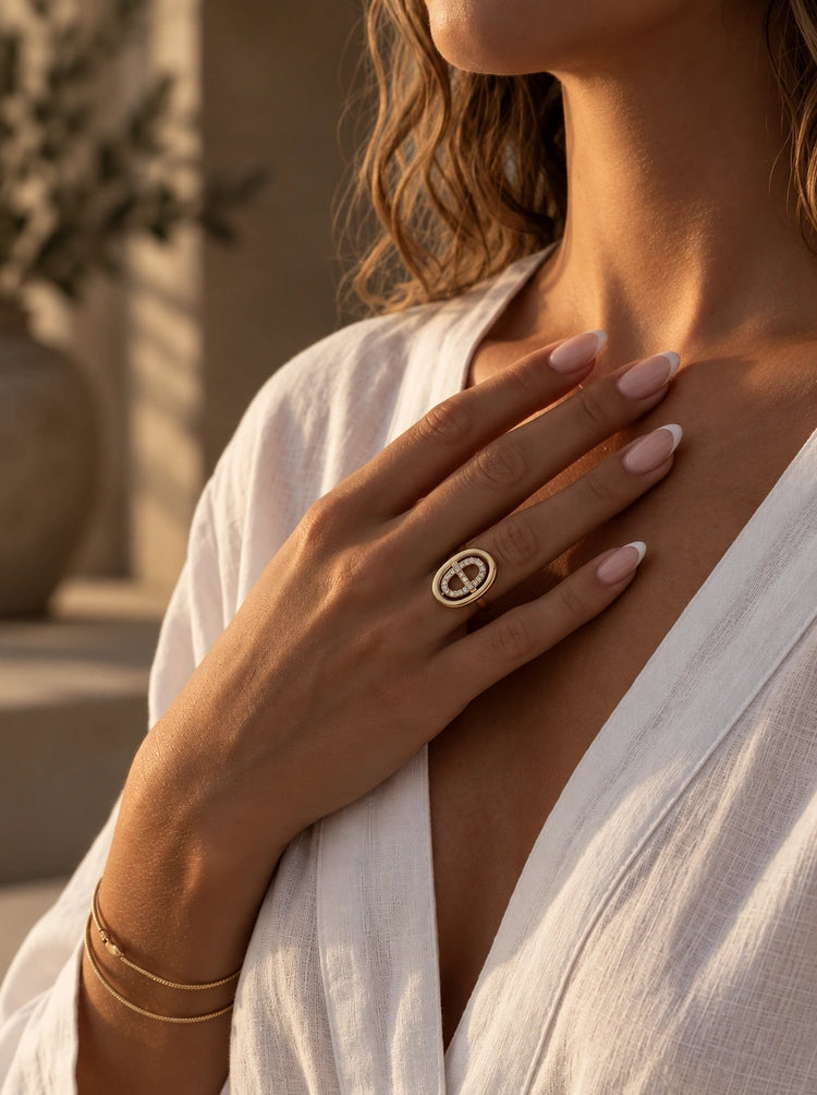 Frau trägt den Lumina Ring in Gold mit Pavé-Zirkonia zur weißen Leinenbluse