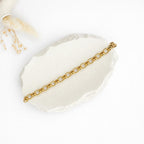Maggie Chain Halskette aus 18k vergoldetem Edelstahl, präsentiert auf einem dekorativen Stein, minimalistisches Schmuckdesign.