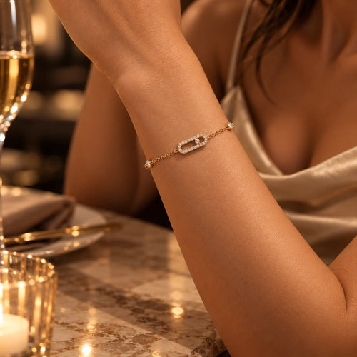 Frau trägt das Maribel Armband in Gold mit Pavé-Zirkonia zum Seidentop am Abendtisch