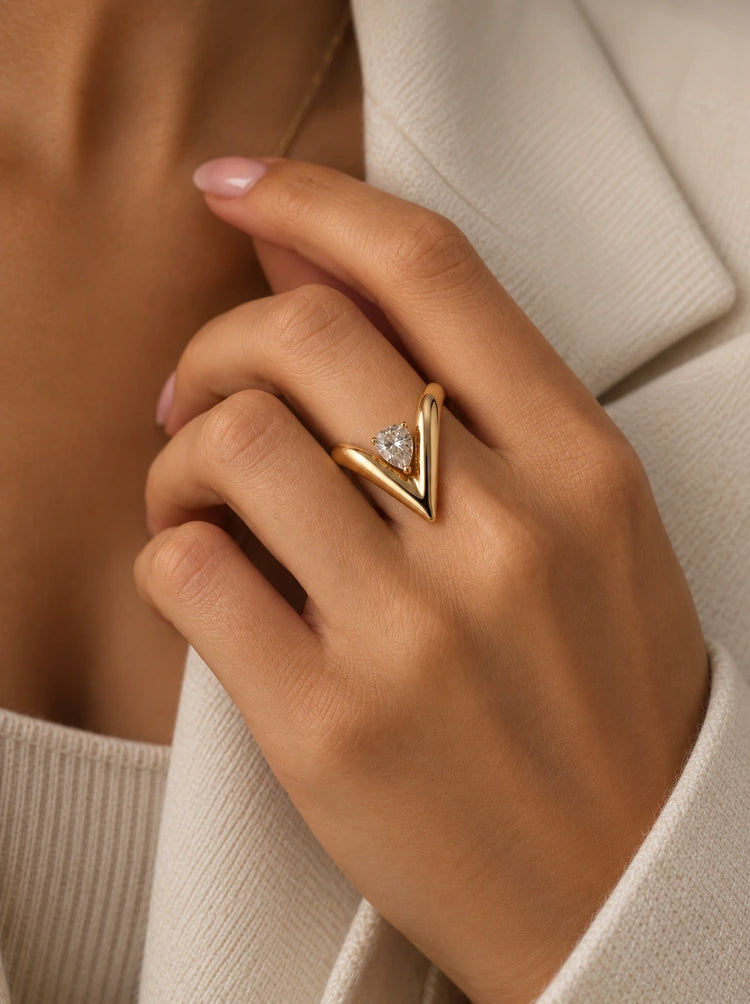 Tragebild des Muse V-Rings aus 14k vergoldetem Edelstahl an der Hand kombiniert mit elegantem Outfit.