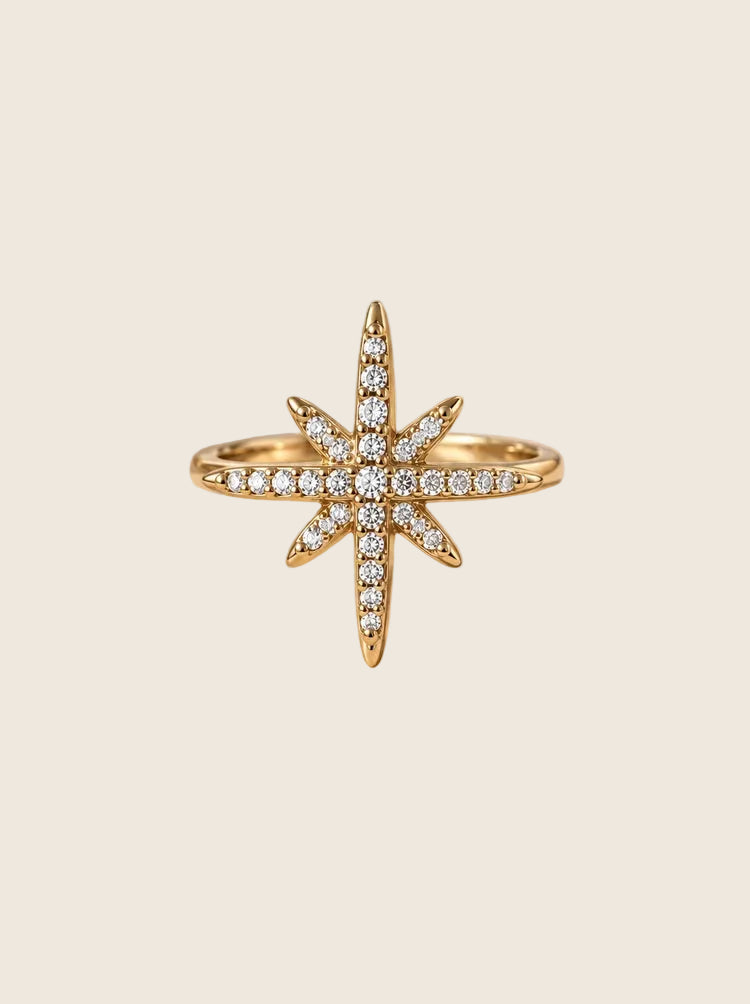 Nahaufnahme des Northern Star Pavé Rings in Gold mit funkelnden Zirkonia-Kristallen auf Naturstein.