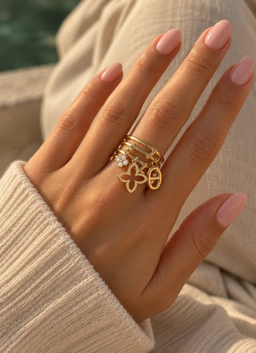 Tragebild des Romina Rings aus 14k vergoldetem Edelstahl mit drei baumelnden Charms an der Hand.