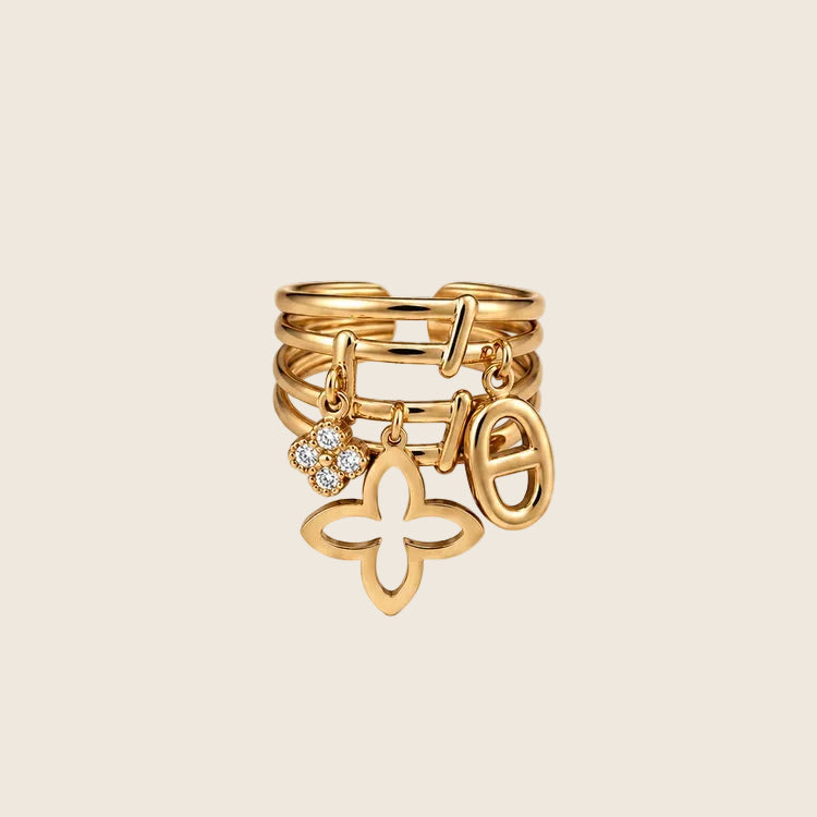Romina Ring in 14k Gold mit drei Anhängern: Kleeblatt-Blüte, ovaler Anker-Charm und Zirkonia-Element.
