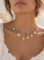 Tragefoto der Sunny Charm Halskette in Gold mit glitzernden Sternen-Anhängern am Hals.