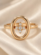Detailaufnahme des Talia Rings in Gold mit ovalem Rahmen und funkelnden Zirkonia-Steinen auf Seide