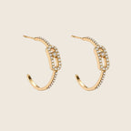 Freigestelltes Paar der Vera Creolen aus 14k vergoldetem Edelstahl mit ovalem Motiv-Glied und Zirkonia-Pavé-Besatz.